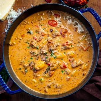 Pot of Tuscan Sausage Gnocchi Soup on a wooden table from overhead.