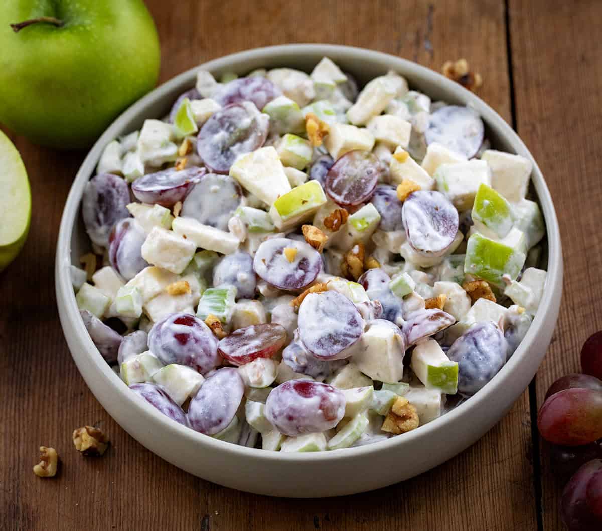Close up of a bowl of Waldorf Salad on a wooden table.