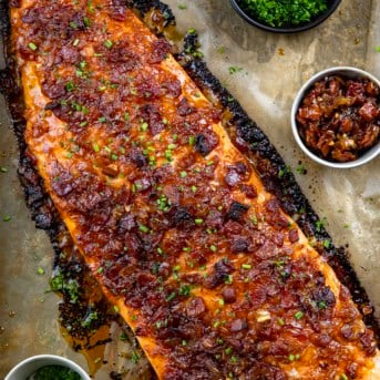 Whole Bacon Jam Salmon on a sheet pan covered with tan parchment paper from overhead.