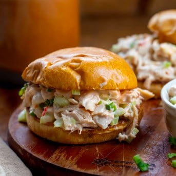 Bang Bang Chicken Salad sandwich on a wooden cutting board.