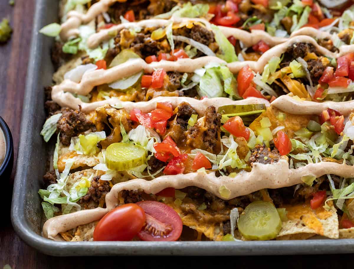 Cheeseburger Nachos are an easy, sheet-pan appetizer that’s perfect for game day or any casual gathering! Close up of a pan of Cheeseburger Nachos.