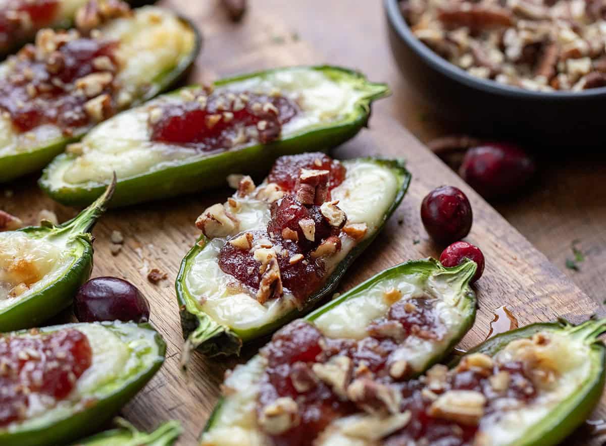 Close up of Cranberry Brie Jalapeño Poppers on a wooden cutting board.