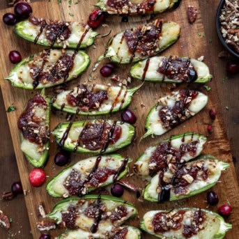 Cranberry Brie Jalapeño Poppers on a cutting board on a wooden table from overhead.
