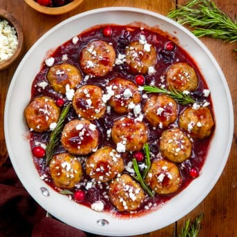 Skillet of Cranberry Feta Chicken Meatballs on a wooden table from overhead.