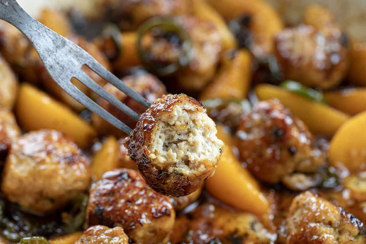 Fork with a bit in half Jalapeño Peach Chicken Meatball on it showing inside texture.