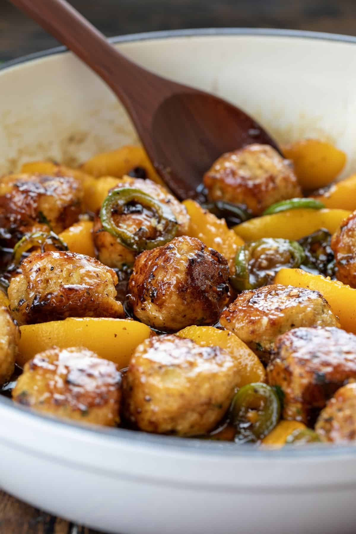 Skillet of Jalapeño Peach Chicken Meatballs very close up with a spoon in the pan.