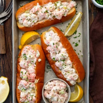Tray of Langostino Lobster Rolls on a wooden table from overhead.