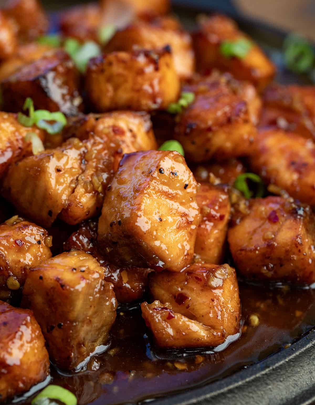 These Maple Glazed Salmon Bites are crispy on the outside, tender in the center, and coated in a sweet-and-savory maple glaze that clings to every bite. Made quickly in the air fryer or oven! Very close up of Maple Glazed Salmon Bites.
