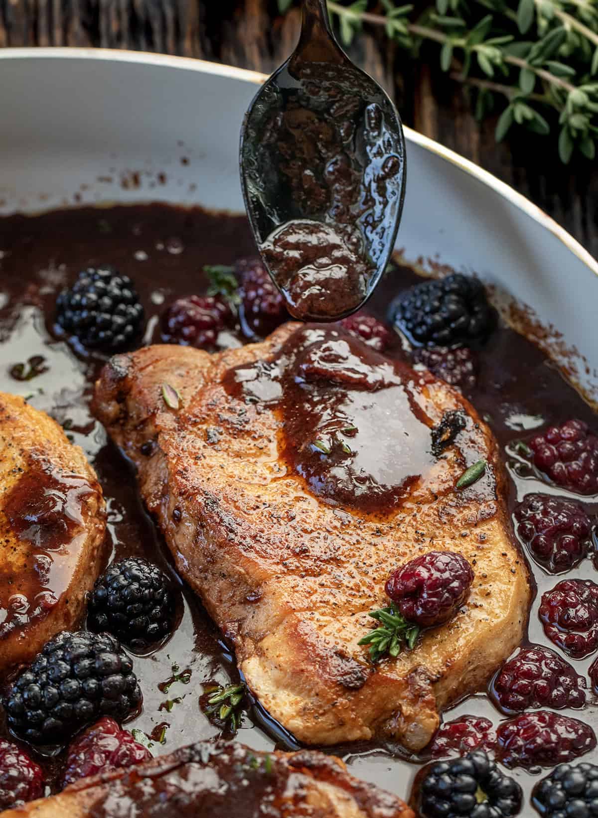 These Bourbon Blackberry Pork Chops are seared until juicy and finished with a glossy blackberry glaze that’s sweet, tangy, and irresistible. Every bite is the perfect balance of savory pork and fruity richness! Drizzling blackberry sauce over Bourbon Blackberry Pork Chops.