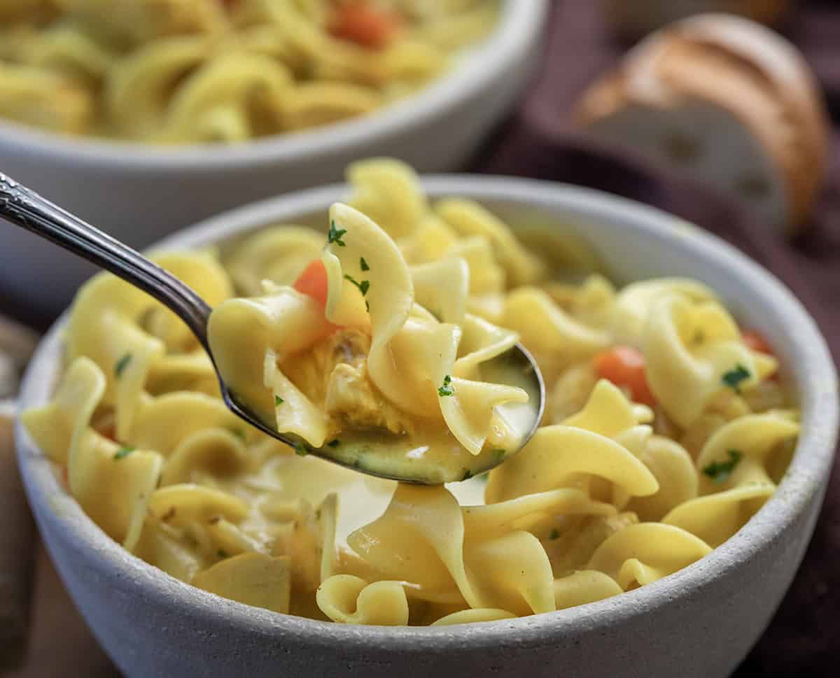 This Ginger Turmeric Chicken Soup is one of those recipes I make when I want something cozy and comforting. It’s a simple, golden soup with tender chicken, warm spices, and a creamy broth. Ginger and turmeric bring gentle warmth, and that beautiful color, and every spoonful feels soothing and nourishing! Spoonful of Ginger Turmeric Chicken Soup held above the bowl.