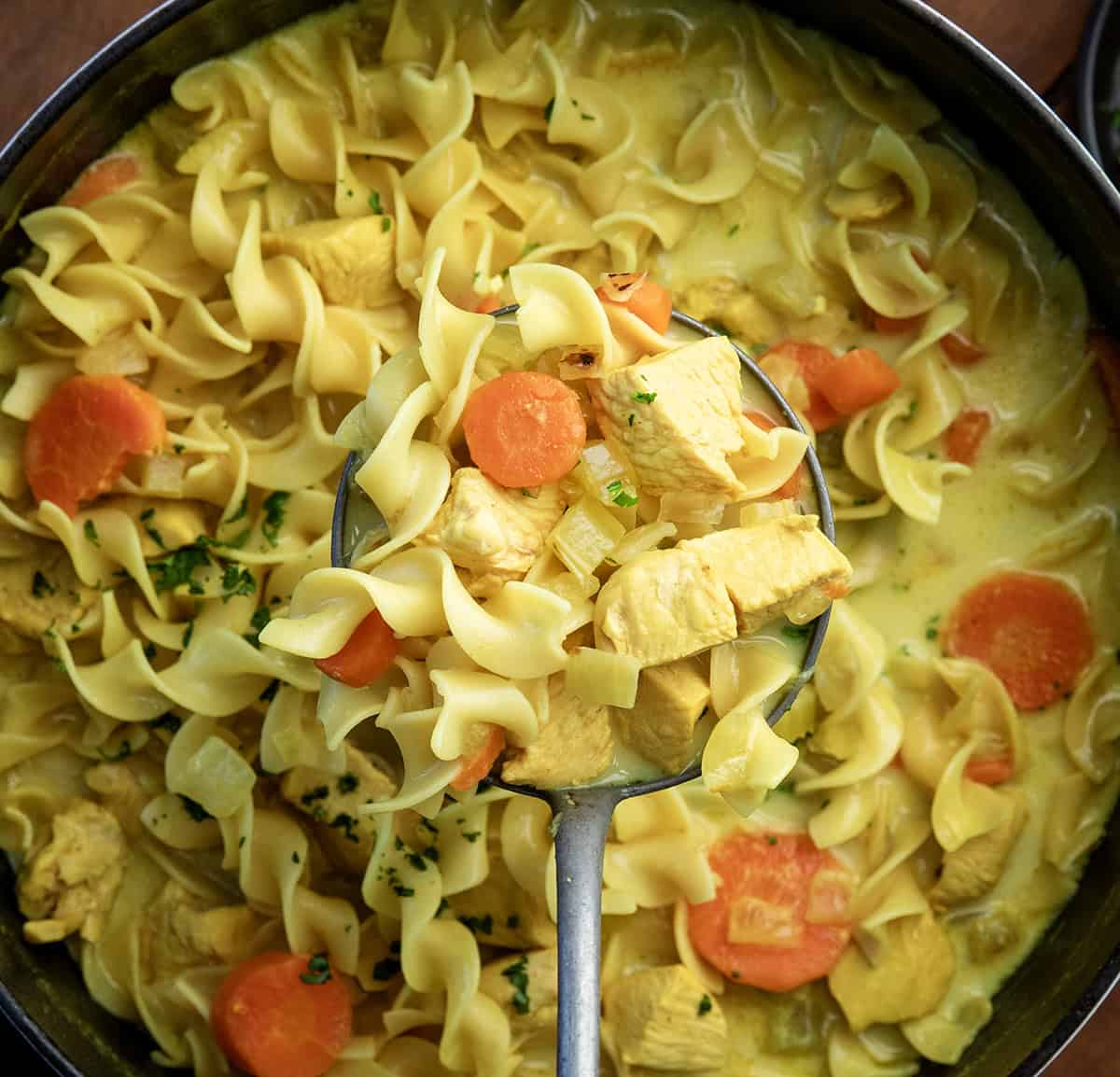 This Ginger Turmeric Chicken Soup is one of those recipes I make when I want something cozy and comforting. It’s a simple, golden soup with tender chicken, warm spices, and a creamy broth. Ginger and turmeric bring gentle warmth, and that beautiful color, and every spoonful feels soothing and nourishing! Ladle full of Ginger Turmeric Chicken Soup held over the pot.