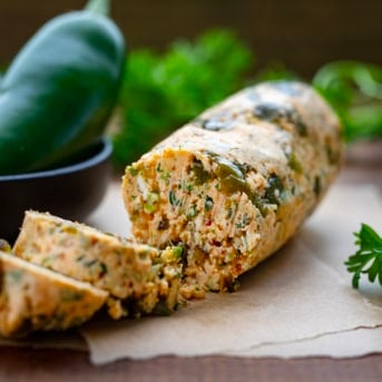 Chilled roll of Roasted Jalapeño Cowboy Butter with some slices cut.