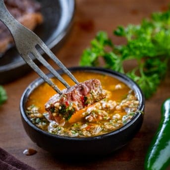 Dipping a piece of steak into Roasted Jalapeño Cowboy Butter.