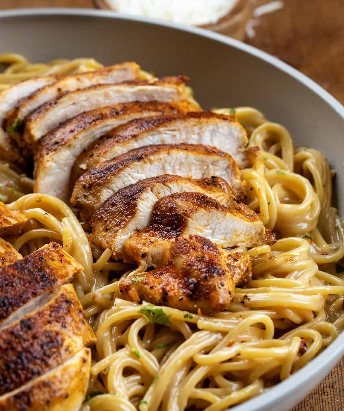 Close up of sliced Sticky Honey Garlic Chicken Pasta with the sliced chicken over noodles.
