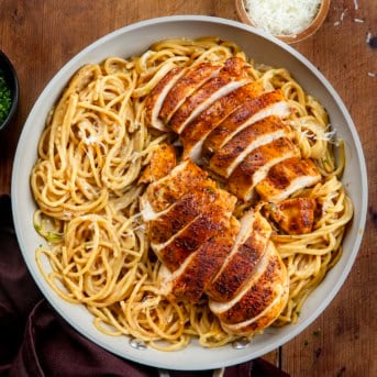 Pan of Sticky Honey Garlic Chicken Pasta on a wooden table from overhead.