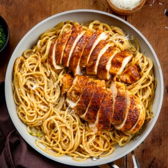 Pan of Sticky Honey Garlic Chicken Pasta on a wooden table from overhead.