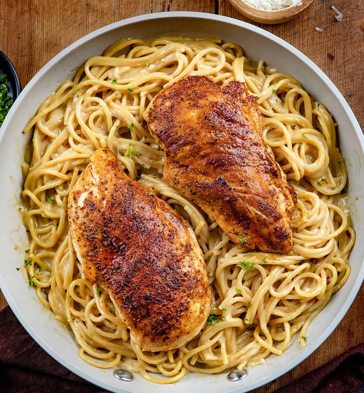Pan of Sticky Honey Garlic Chicken Pasta on a wooden table from overhead.