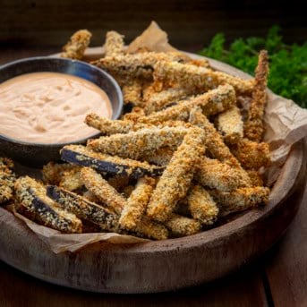 Wooden bowl of Eggplant Fries with chipotle aioli dipping sauce.