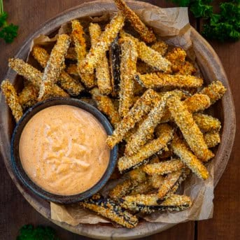 Bowl of Eggplant Fries on a wooden table from overhead.