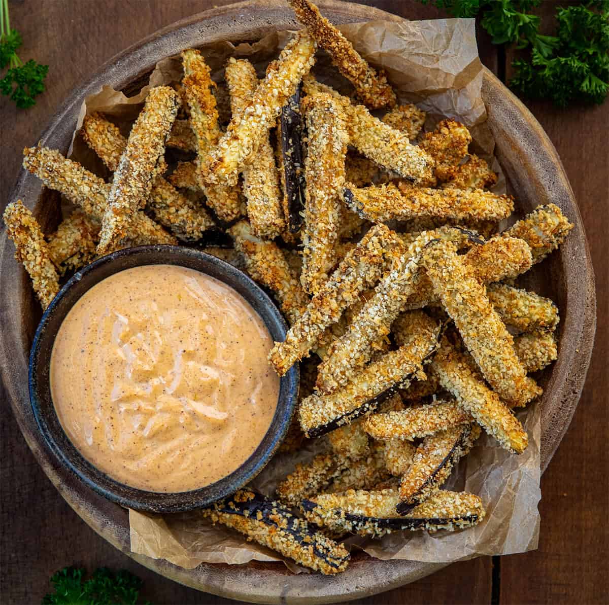 Crispy, golden, and totally snack-worthy, these Eggplant Fries are about to change how you feel about eggplant! Seriously, you have to give them a try. They’re coated in a crunchy Parmesan-panko crust, baked (or air-fried!), and served with a smoky chipotle aioli that’s perfect for dipping! Bowl of Eggplant Fries on a wooden table from overhead.