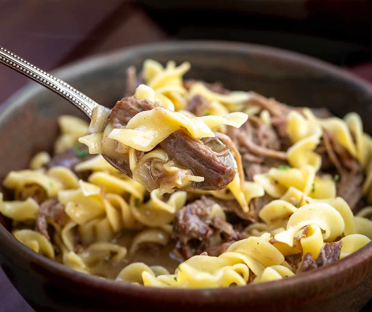 This Slow Cooker Beef and Noodles is a cozy, family-friendly dinner with tender, fall-apart beef, rich savory gravy, and soft egg noodles. Easy to make and perfect for busy weeknights or a comforting weekend meal. Spoonful of Beef and Noodles very close up.