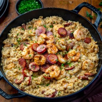 Skillet of Cajun Shrimp and Sausage Rice on a wooden table from overhead.