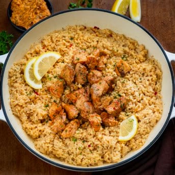 Pot of Cowboy Butter Chicken and Rice on a wooden table with fresh lemon.