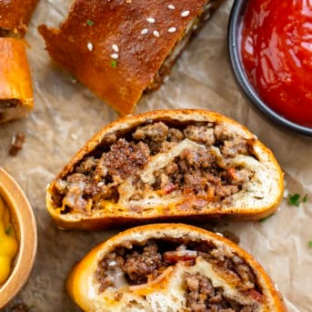 Slices of Garbage Bread on tan parchment paper with ketchup and mustard.