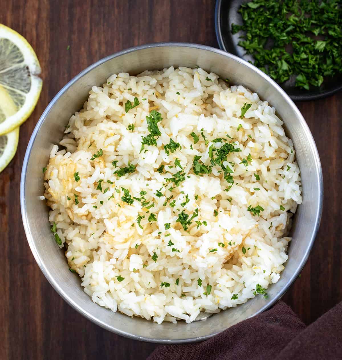 Elevate your meals with Lemon Rice, a flavorful side dish made with fresh lemon juice and butter for perfect tenderness! Pot of Lemon Rice on a wooden table from overhead.