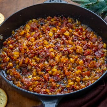 Skillet of Pineapple Bacon Jam on a wooden table.