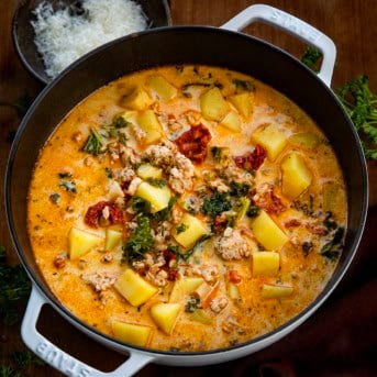 Pot of Tuscan Chicken Potato Soup on a wooden table from overhead.