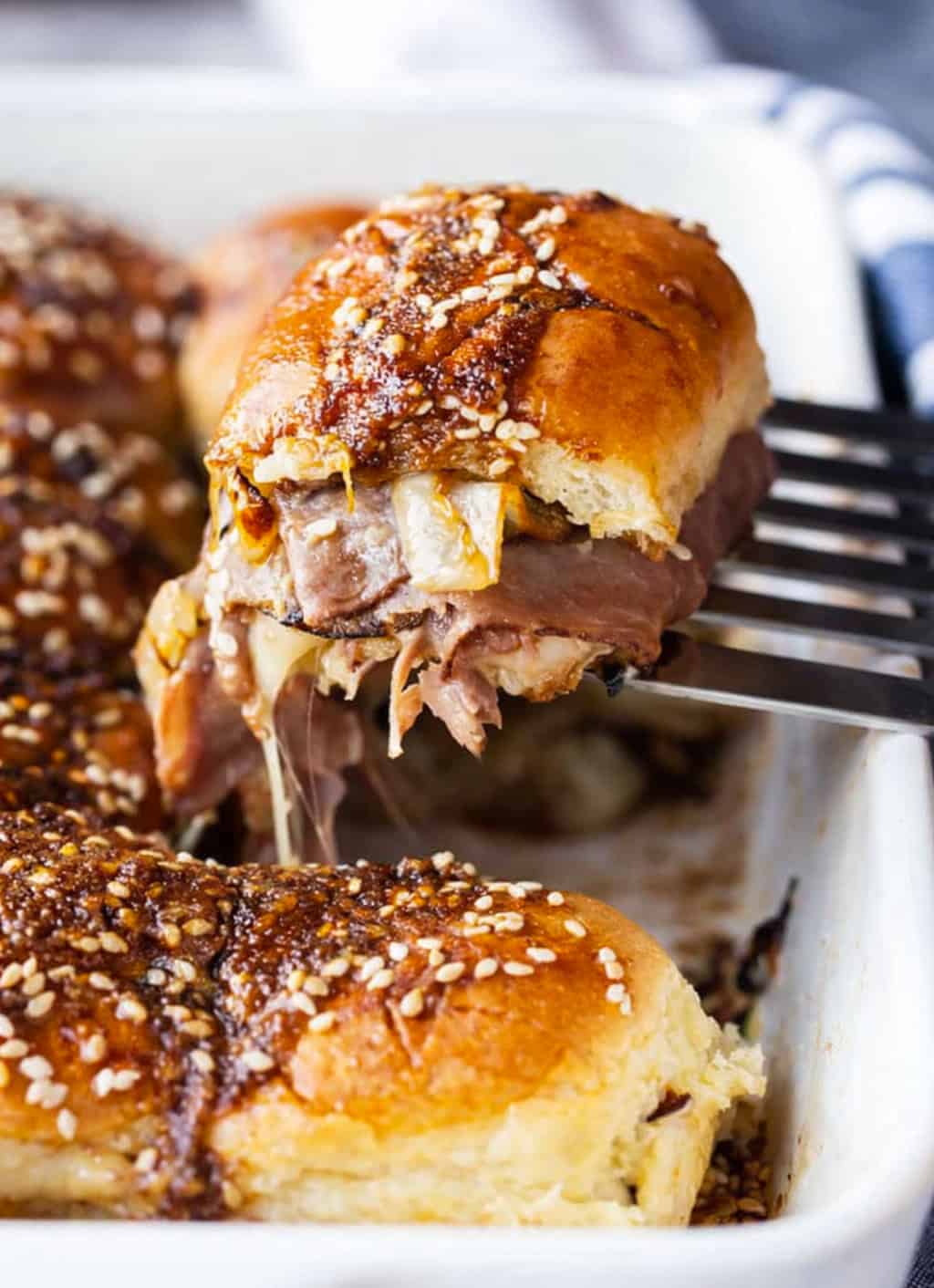 Sliders are one of the easiest ways to feed a crowd. They’re fun, customizable, and perfect for parties, game days, holidays, and family dinners! Picking up a French Dip Slider from the pan.