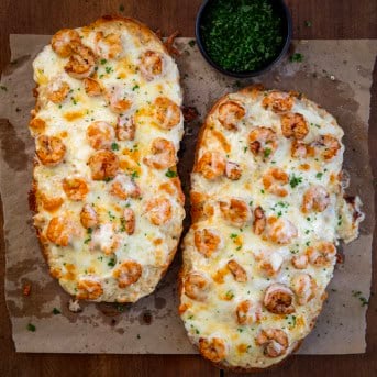 Shrimp Alfredo Garlic Bread on a wooden table from overhead.