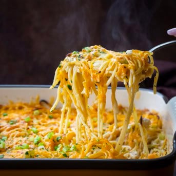 Scoop picking up a portion of Cajun Chicken Spaghetti with steam rising.