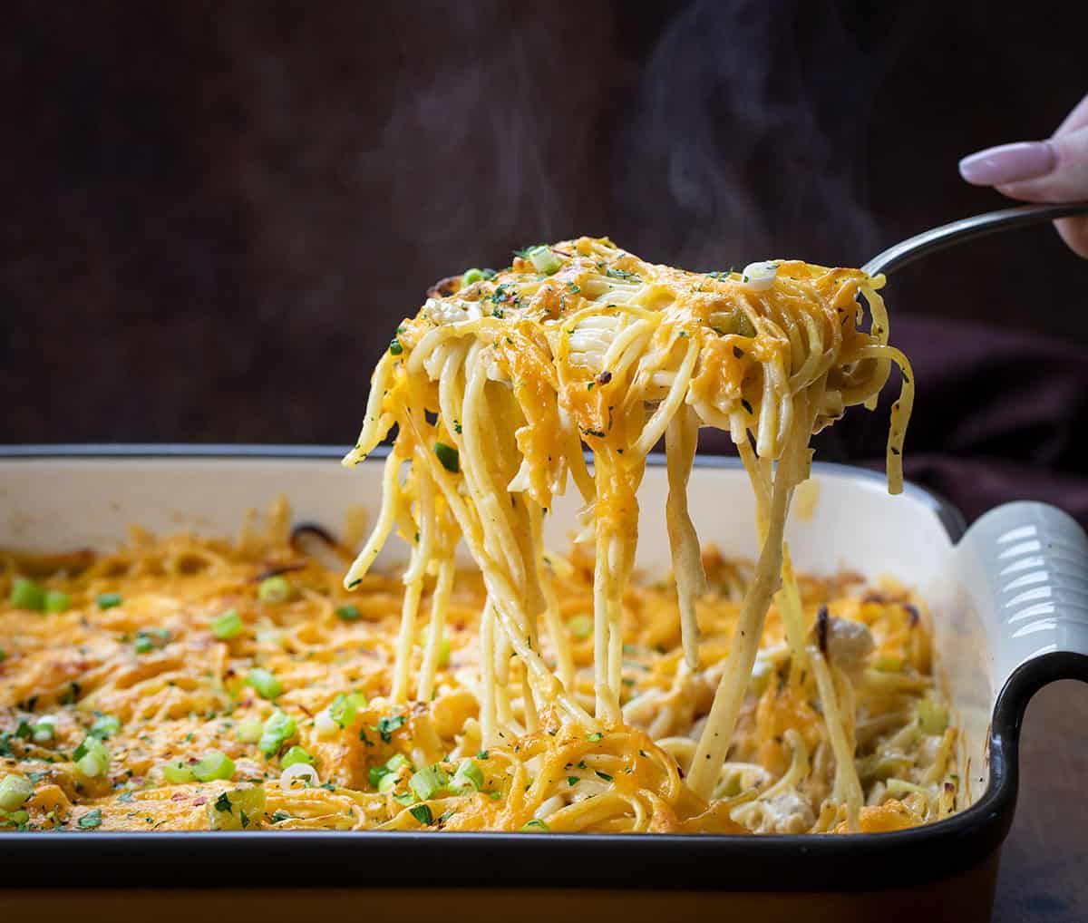 Scoop picking up a portion of Cajun Chicken Spaghetti with steam rising.