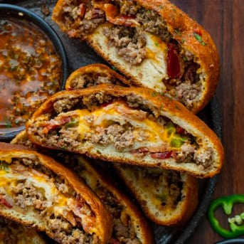 Slices of Cowboy Garbage Bread cut and on a platter with Cowboy Butter.