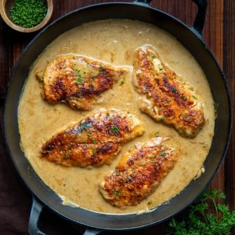 Skillet of Easy Chicken and Gravy on a wooden table from overhead.