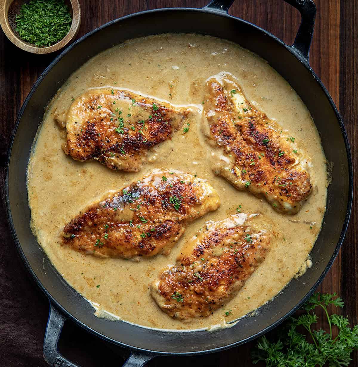 Easy Chicken and Gravy is a cozy, comforting dinner made with tender pan-seared chicken and a rich homemade onion gravy. Skillet of Easy Chicken and Gravy on a wooden table from overhead.