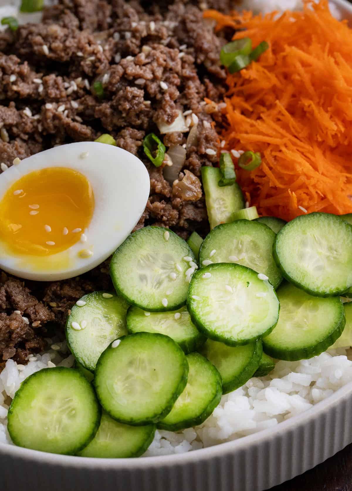 Very close up view of cucumbers on a Ground Beef Bulgogi Bowl.