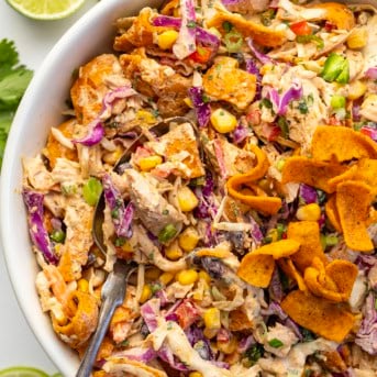 Close up of a spoon filled with Loaded Chicken Frito Cowboy Cabbage.