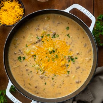 White pot of Ranch Cheesy Beef and Potato Soup on a wooden table from overhead.