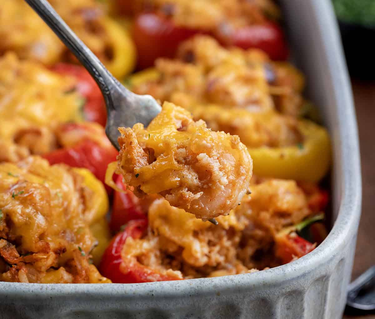 These Seafood Stuffed Bell Peppers are colorful, flavorful, and surprisingly easy to make. Sweet bell peppers cradle a tender mix of shrimp, jumbo lump crab, and seasoned rice, all topped with melted cheddar cheese! Some filling from a Seafood Stuffed Bell Pepper on a fork.