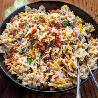 Black bowl filled with Southwest Pasta Salad on a wooden table from overhead.