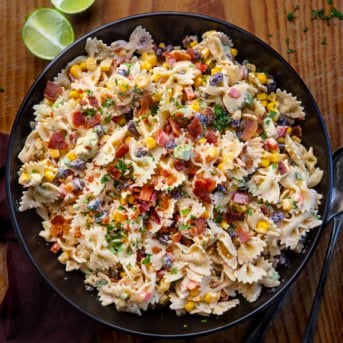 Black bowl filled with Southwest Pasta Salad on a wooden table from overhead.