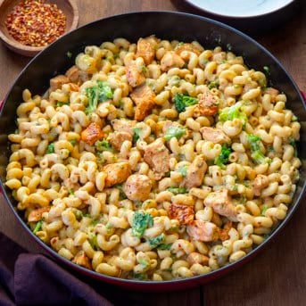 View of a red skillet filled with White Cheddar Chicken Pasta with Broccoli.