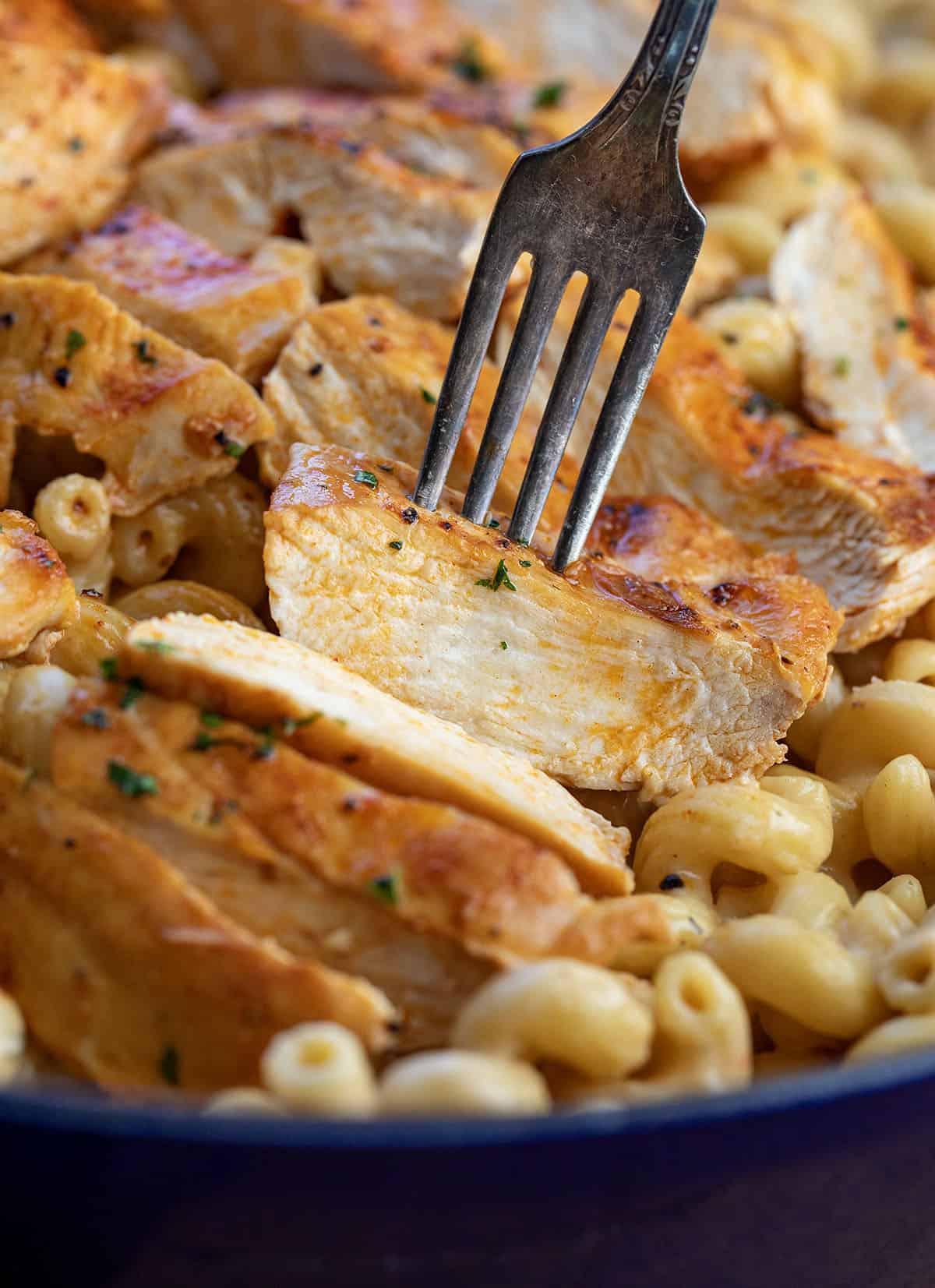 Fork picking up a piece of White Cheddar Ranch Chicken Pasta.