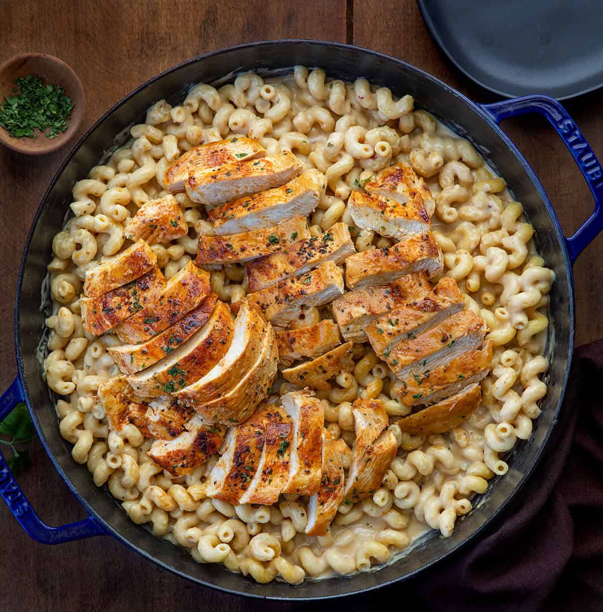 White Cheddar Ranch Chicken Pasta with the chicken cut into slices on a wooden table from overhead.