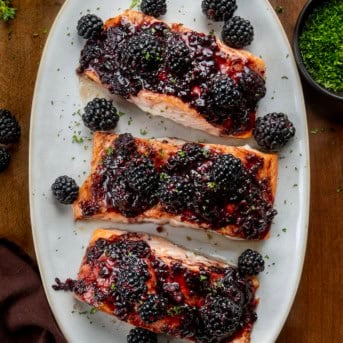 Bourbon Blackberry Salmon on a platter on a wooden table from overhead.