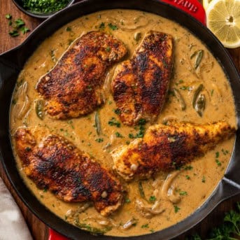 Skillet of Cajun Chicken and Gravy on a wooden table from overhead.