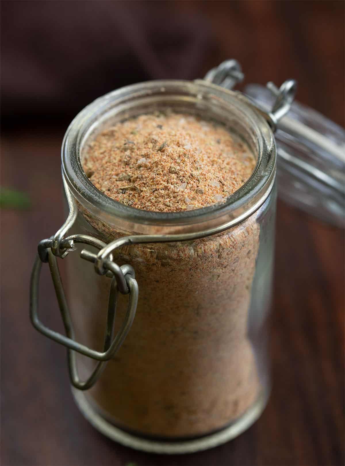 This homemade Cajun seasoning is the kind of simple pantry staple that makes everyday cooking a little more exciting. It comes together in just a few minutes and gives you that classic Cajun flavor you can sprinkle on just about anything. Close up of a jar of Cajun Seasoning on a wooden table.